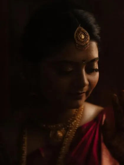 A moody and artistic bridal portrait, with the bride's face gently illuminated in the dark.