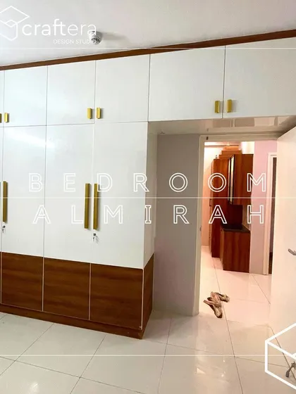 This two-tone wardrobe combines white and wood laminate for a classic look. The sleek gold handles add a modern, elegant touch, and the loft provides extra storage space.