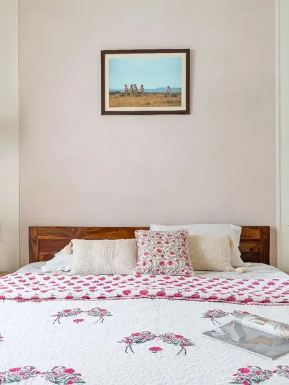 This bedroom showcases a muted color palette and symmetrical design. The matching pendant lights on either side of the bed enhance the room's calm and cozy atmosphere.