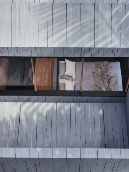 Details from the two-tiered bedroom retreat. The design includes an open-to-sky shower and a private balcony, blurring the lines between indoor and outdoor living. The minimalist palette of concrete and wood ensures that the focus remains on the tranquil, natural surroundings.