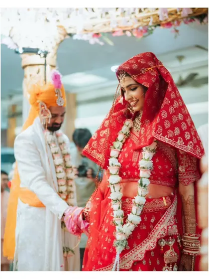 The couple holding hands during their 'pheras' around the sacred fire in a North Indian wedding.