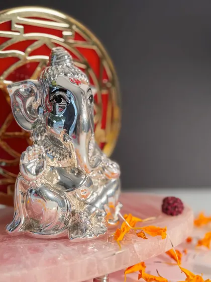A detailed close-up of my silver-plated Ganesha idol, showing the fine craftsmanship in his eyes and the sacred tilak on his forehead.