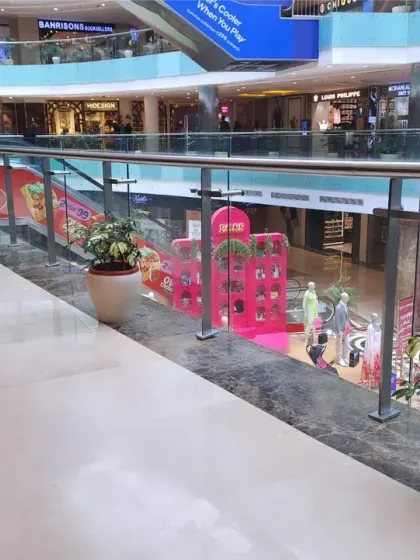 The strategic placement of planters along the railing provides a continuous line of greenery, softening the hard lines of the mall's interior and improving the overall shopping experience.