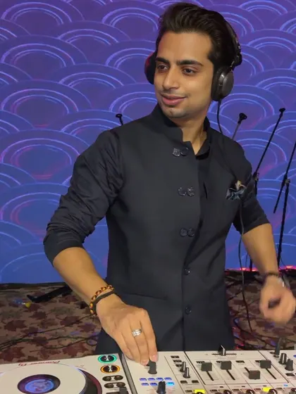 Bringing the beats to life. A focused shot of me working the mixer against a cool, patterned blue backdrop.