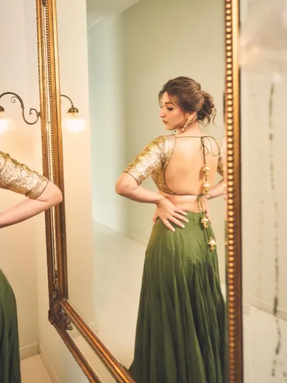 The back of an outfit is just as important as the front. This mirror shot reveals the beautiful backless design of the sequined gold blouse.