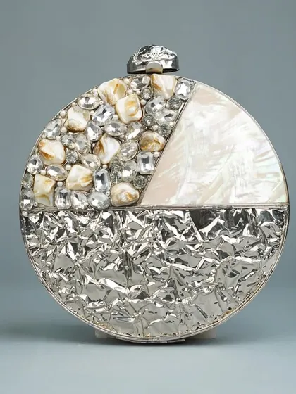 This circular clutch combines different textures and materials for a contemporary feel. It features a mix of crushed silver-tone metal, mother of pearl, and sparkling stones, creating a truly unique party accessory.