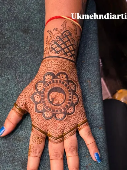 This design features a beautiful elephant inside a floral mandala. The fingers are left with some negative space, which makes the detailed work on the palm pop.