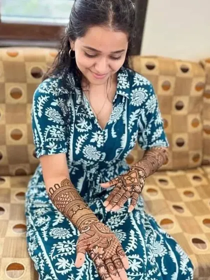 A happy client looking down at her freshly applied mehendi. I love capturing these moments of excitement as the design comes to life.