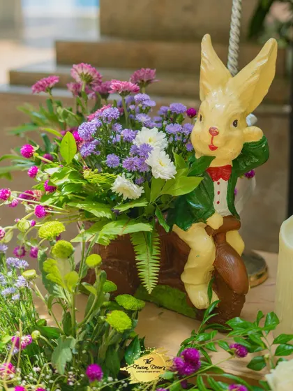A whimsical detail from the baby shower decor. This cute rabbit figurine, nestled in a floral arrangement, adds a touch of storybook charm to the celebration.
