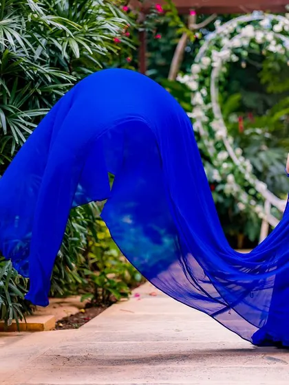 Capturing the gown in motion against a heart-shaped floral arch. This shot combines the elegance of the flowing blue fabric with a classic symbol of love for a perfect pre-wedding photo.