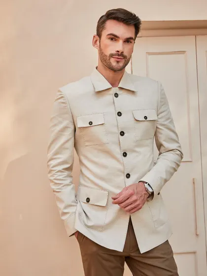 A front-on view of the beige shacket, highlighting its clean lines, four-pocket design, and contrasting buttons.