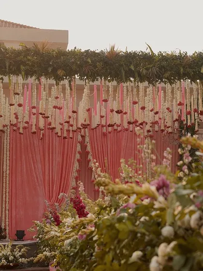 A closer look at the floral details of the mandap. We used a mix of white, pink, and deep magenta flowers to create a rich, textured look along the aisle, leading to the beautifully draped stage.