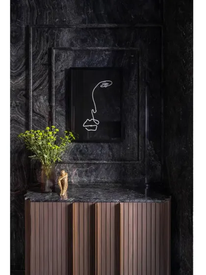 A moody and dramatic bathroom in the Skyward Residence. The walls are clad in a beautiful black marble, with a fluted wood vanity providing a warm, textural contrast.