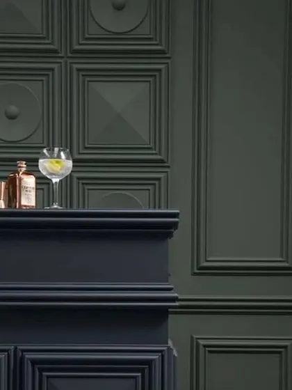 A close-up of classic wainscoting in a deep, moody green. This type of wall treatment adds architectural depth and a touch of traditional elegance, perfect for creating a cozy bar area or study.