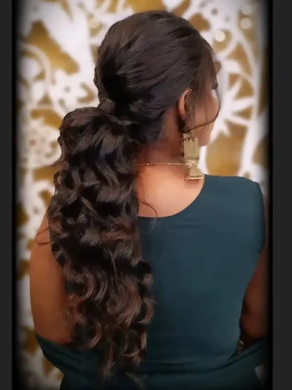 The hairstyle for this party look, a chic and voluminous ponytail with soft waves.