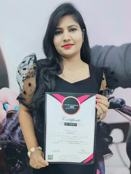 A graduating student holding her Certificate of Merit from Lakme Academy. It's a joy to see my students achieve their goals and earn their professional certification.