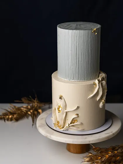 This elegant tiered cake combines a textured grey tier with a smooth beige tier featuring abstract details. I'll teach you the techniques for doweling, stacking, and creating these contemporary designs.