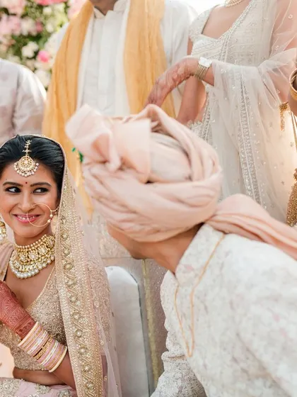 A beautiful candid moment during the pheras, where the bride looks at her groom with a radiant smile, capturing the happiness of the ritual.