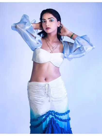 A dynamic pose from our water-themed series. The model's pose highlights the movement in the ruffled sleeves and the ombre dye of the skirt.