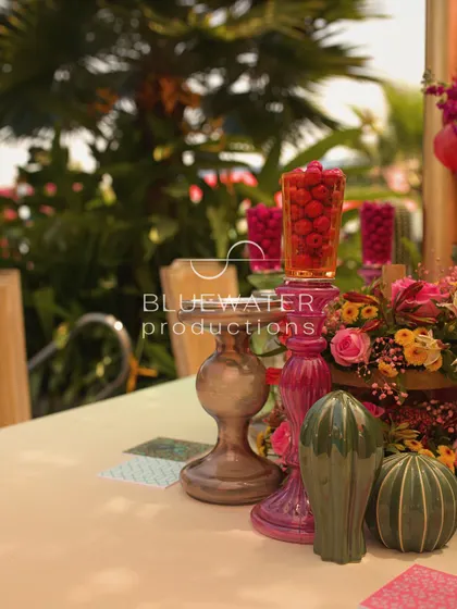 Fresh raspberries in colored glass vases add a pop of color and a touch of the unexpected to the decor.