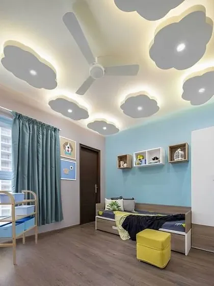 A simple and effective kids' room design with multiple cloud-shaped lights on the ceiling. The light blue wall and wooden flooring create a calm and pleasant environment.
