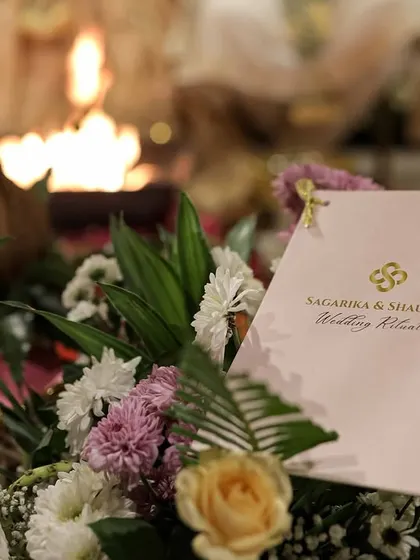 A personalized wedding itinerary card, beautifully placed within a floral arrangement, showcasing our attention to every little detail.