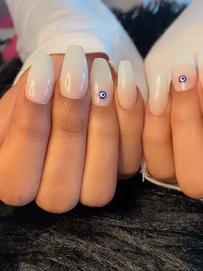 A milky white base with a simple evil eye charm for a touch of protection and style.