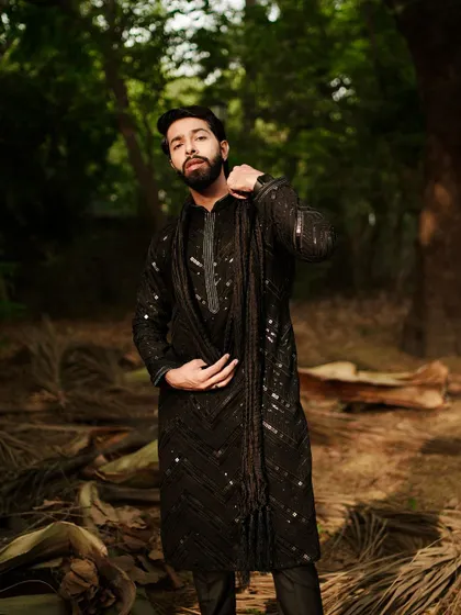 Serving looks hotter than a Delhi summer. This all-black sequined kurta with a matching stole is a statement piece for the man who isn't afraid to shine.