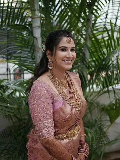 A candid shot of the bride in her dusty rose ensemble, her happy smile is the best accessory.