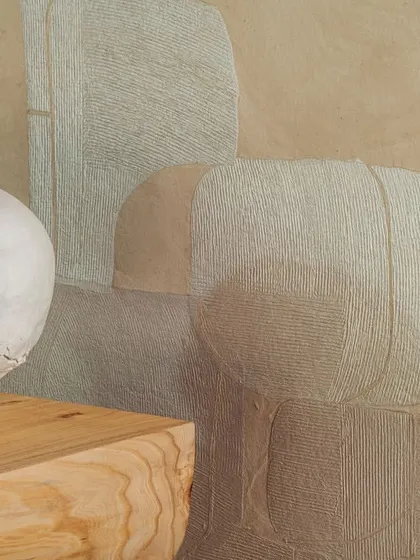 A close-up of the 'Voyage Initiatique' wallcovering from the Hanji collection. The layered paper fragments and subtle textures create a serene, contemplative surface, offering a sanctuary from the chaos of the outside world.