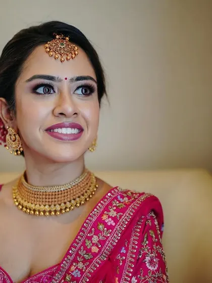 A close-up portrait capturing the bride's happy and hopeful expression. Her flawless makeup and stunning jewelry are highlighted in this beautiful shot.