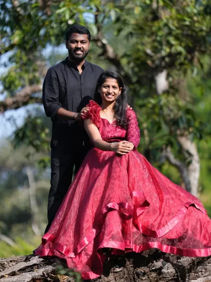 A beautiful couple's portrait in the woods. The red organza gown with its ruffled shoulder detail is a fashionable and unique choice.