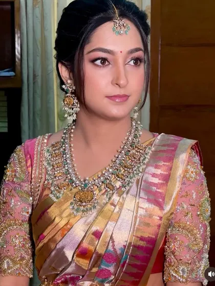 This mom-to-be looks absolutely radiant. Her custom-designed blouse with intricate embroidery perfectly complements her beautiful saree.