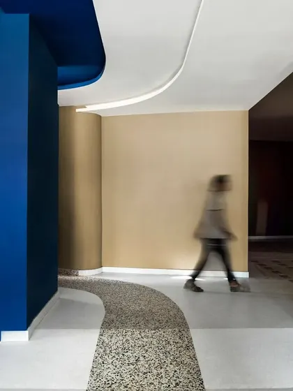 A curved corridor at the MARC Auditorium, where a path of terrazzo flooring guides movement. The interplay of color, material, and form creates a series of distinct yet connected spatial experiences.