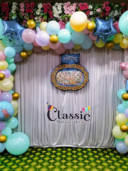A Peppa Pig themed decoration for a naming ceremony, using a pastel balloon arch and a traditional centerpiece.