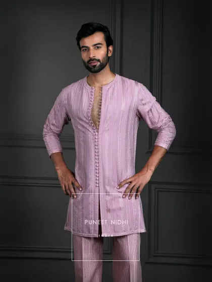 Inspired by heritage, designed for today. This dusty salmon kurta set features subtle sheen, loop buttons, and woven geometry that embody timeless sophistication.