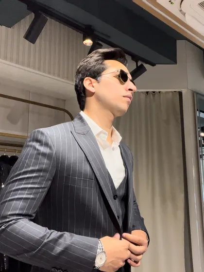 Another angle of the three-piece pinstripe suit, showing how the tailored fit flatters the physique and creates a clean, professional line from shoulder to waist.