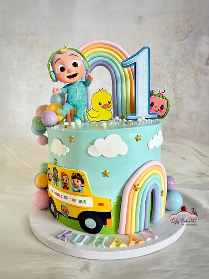 The wheels on the bus go round and round! This Cocomelon cake was for a first birthday, featuring the iconic yellow school bus and a pastel rainbow.