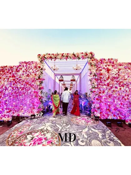A beautiful floral entrance tunnel designed to wow guests as they arrive. The walls are covered in thousands of pink and white flowers, creating an immersive and luxurious welcome experience.