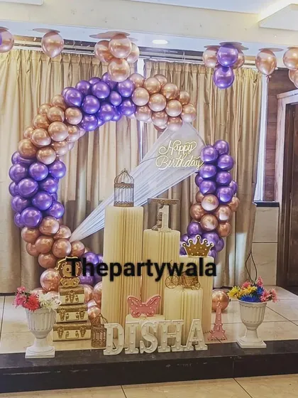 A glamorous ring decoration with purple and rose gold balloons, set on a stage for a grand party.