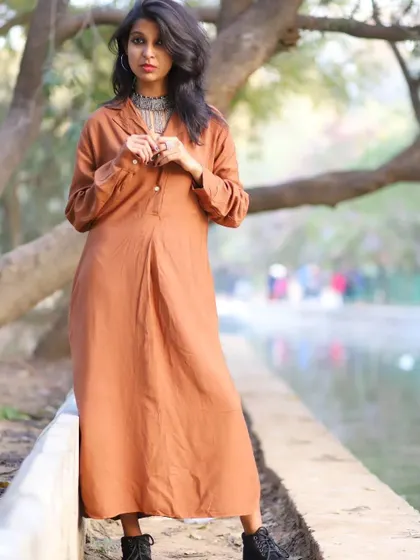 Posing by the water during the same shoot. The natural setting perfectly complemented the minimalist and rustic vibe of the outfit.