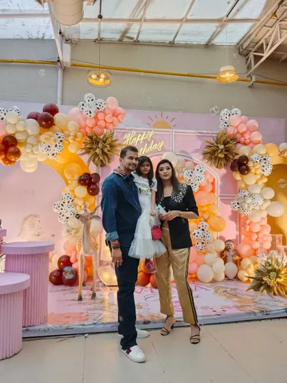 The birthday girl and her family pose in front of the beautiful pastel animal-themed backdrop, a perfect setting for creating lasting memories.