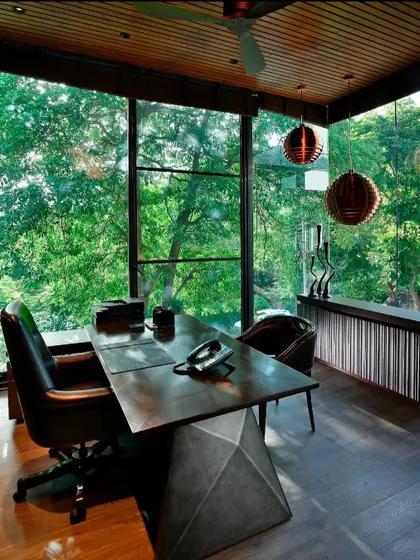 Another glimpse of the T House study, showing its relationship to the main house. The design uses a consistent material palette of wood, stone, and glass to create a cohesive architectural language throughout the project.