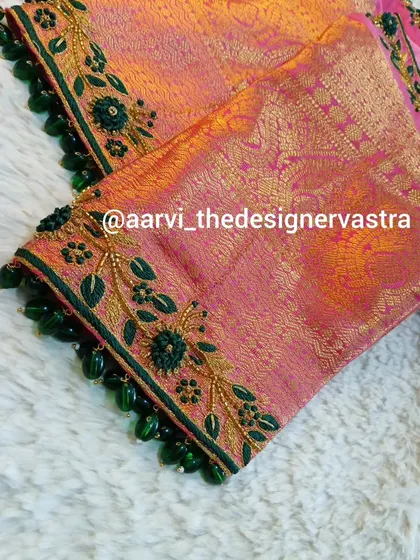 A detailed shot of the sleeve embroidery on the pink and orange blouse, showing the fine threadwork and bead detailing.
