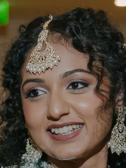 A candid shot of a happy bride during her engagement. The makeup is subtle, with a focus on glowing skin and soft eyes, and the photo is completely unedited.