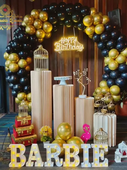 A bold 'Barbie' themed party using a black and gold color scheme, with marquee letters, a balloon ring, and a neon sign.