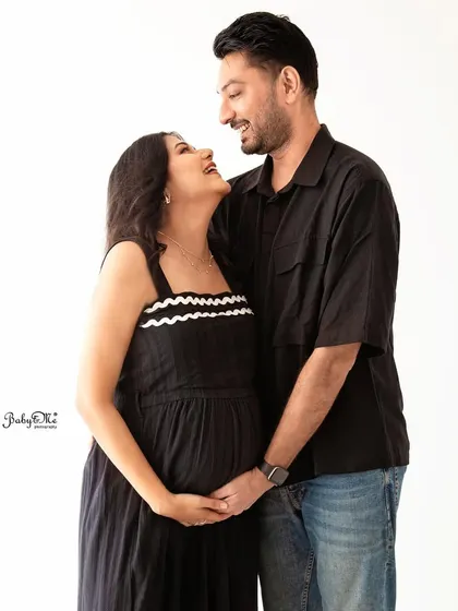 A candid, laughing moment between the expecting couple. My minimalist white backdrop sessions allow your joy and connection to be the main focus.