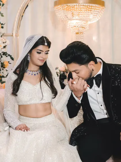 A chivalrous gesture as the groom kisses the bride's hand after the ring exchange. This romantic moment is captured beautifully against the elegant decor.