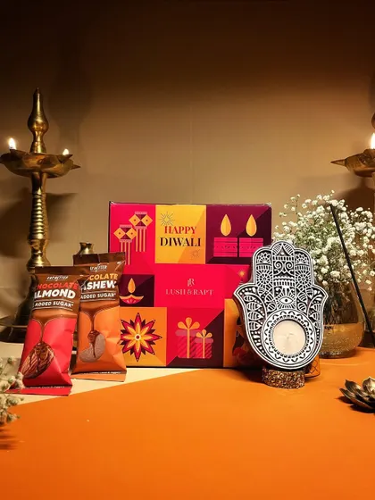 Our "Shimmer and Shine" Diwali hamper, featuring a Hamsa hand candle holder and sugar-free treats, is a perfect festive gift under ₹999.