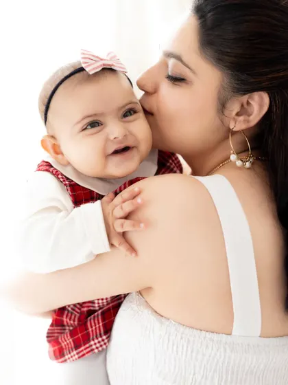 A mother's gentle kiss on her baby's cheek. These simple, light-filled portraits are perfect for capturing the pure love and connection with your little one.